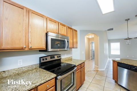A kitchen with wooden cabinets and a granite countertop.