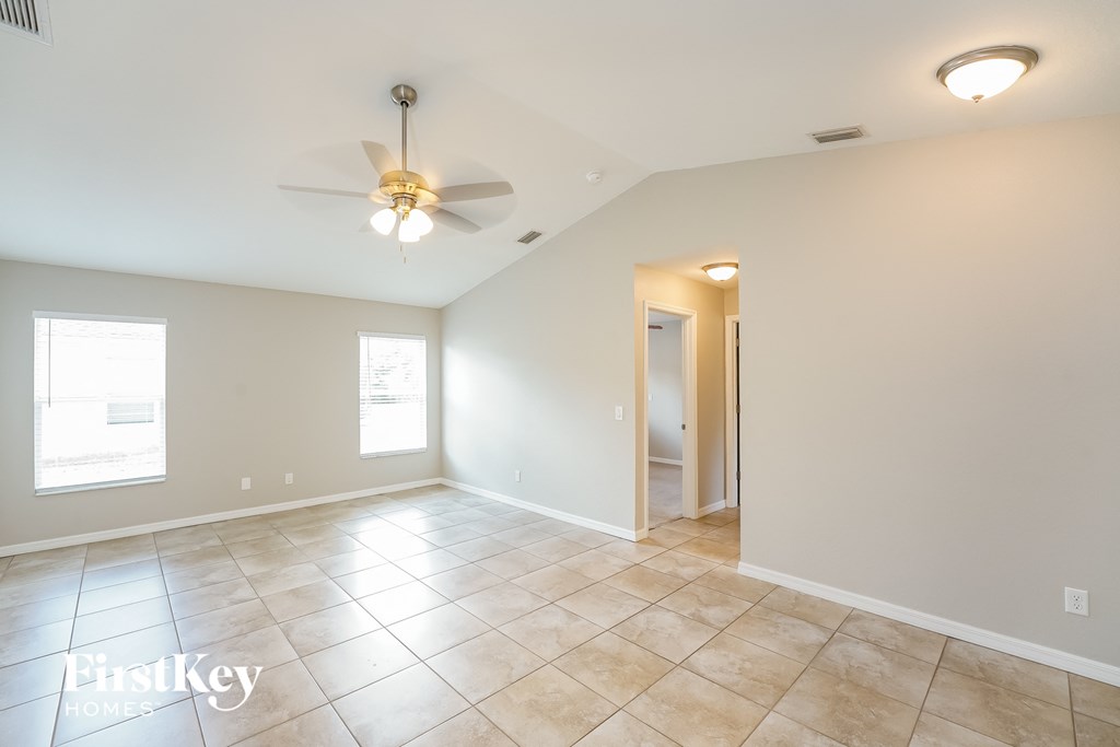 A spacious room with a ceiling fan and tile flooring.