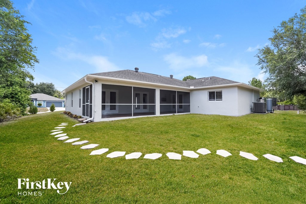 A white house with a curved driveway in front of it.
