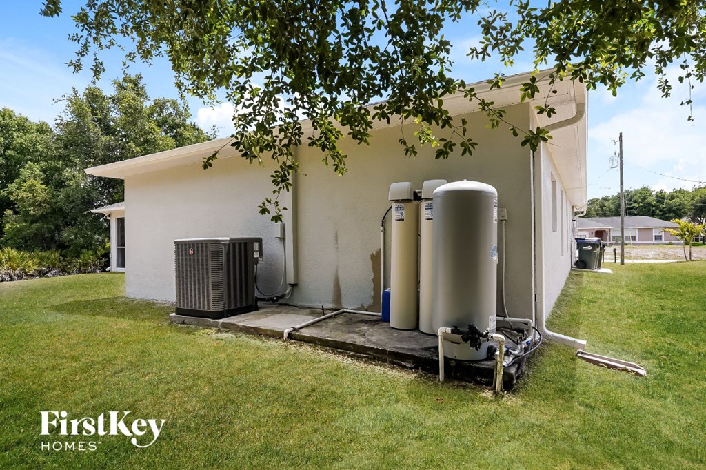 A FirstKey Homes sign is on a white house with a tree in the foreground.