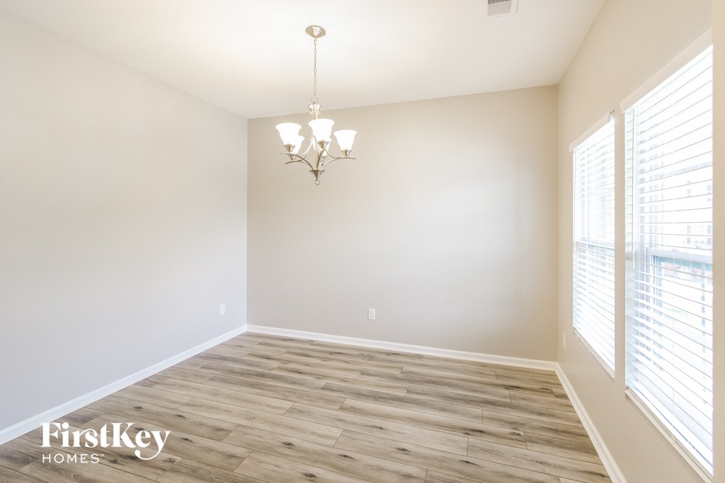an empty living room with wood floors and white walls