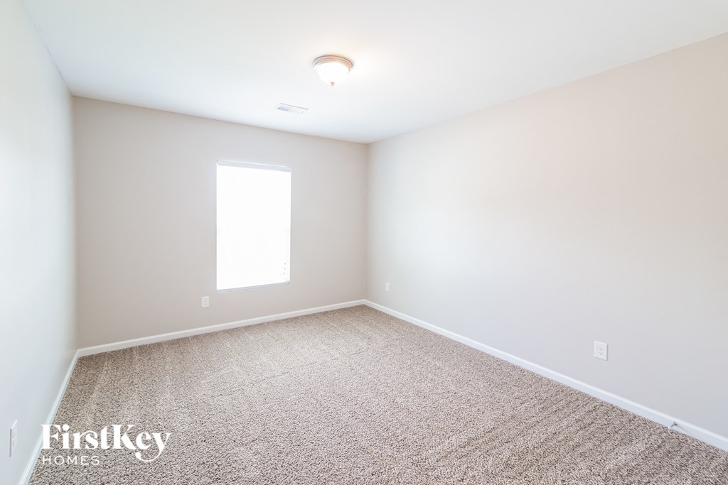 a empty room with carpet and a window