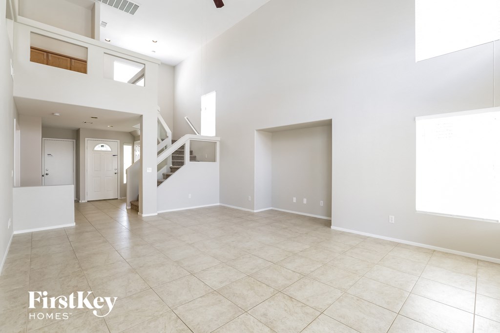 an empty living room with a staircase in a house