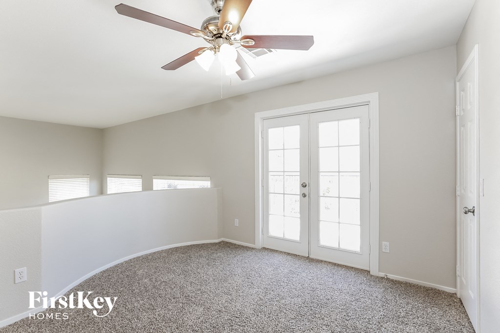 a bedroom with white walls and a ceiling fan