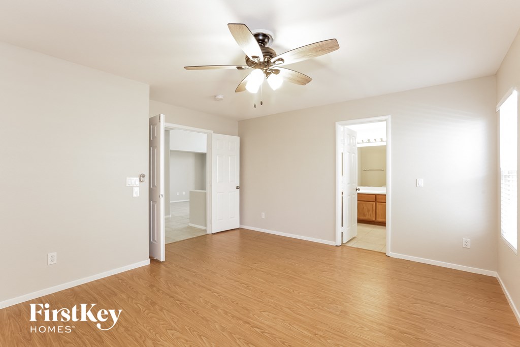 a spacious living room with wood flooring and a ceiling fan