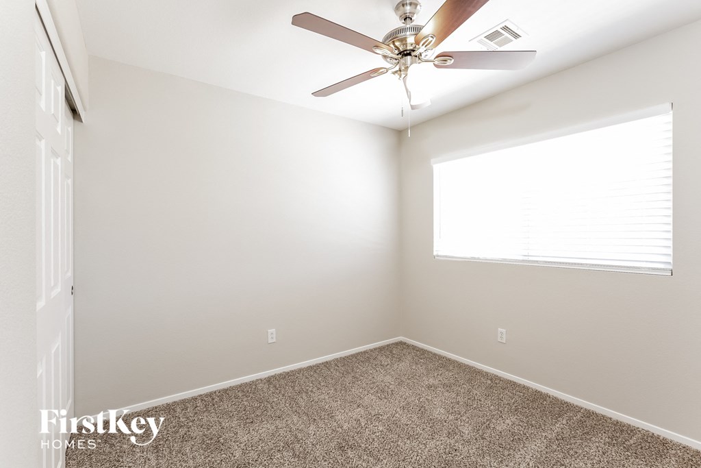 a bedroom with a ceiling fan and a window