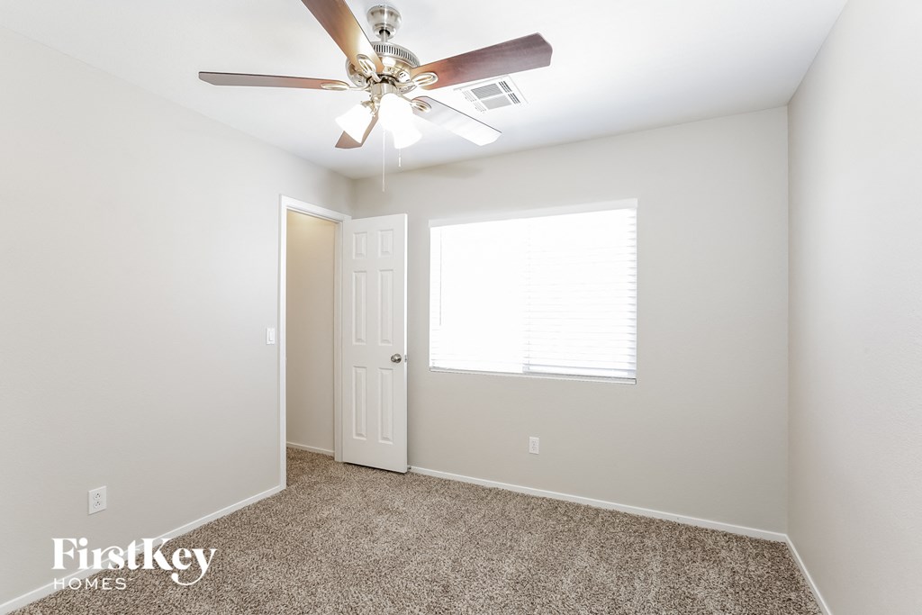 a bedroom with a ceiling fan and a window