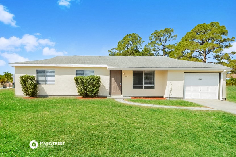 a white house with a lawn and a garage
