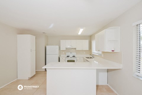 a white kitchen with white cabinets and a white counter top