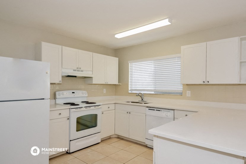 a white kitchen with white appliances and white cabinets