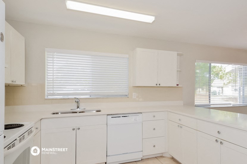 a white kitchen with white cabinets and a sink
