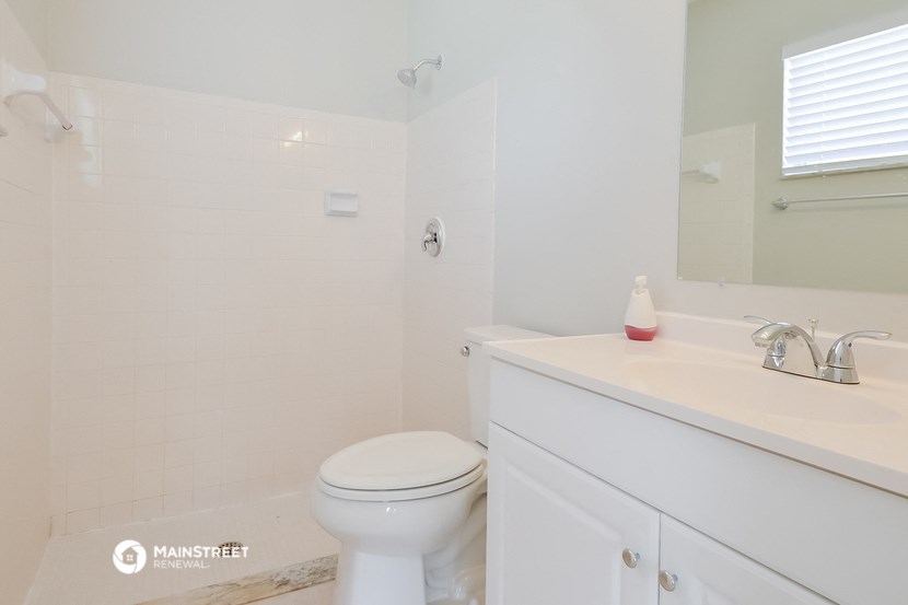 a white bathroom with a toilet and a sink