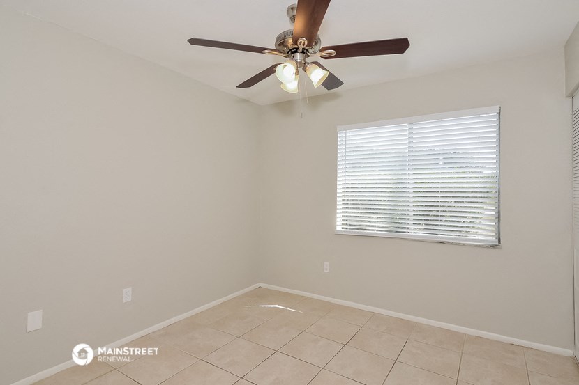 a empty room with a ceiling fan and a window