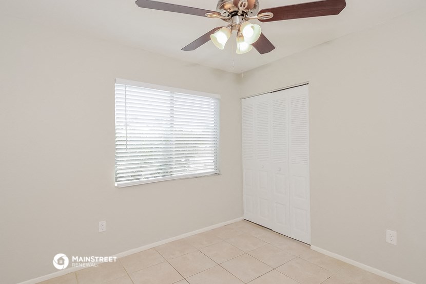 a empty room with a ceiling fan and a window