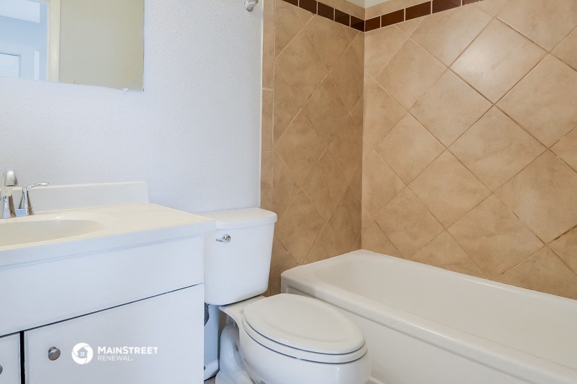 a bathroom with a toilet and a tub and a sink