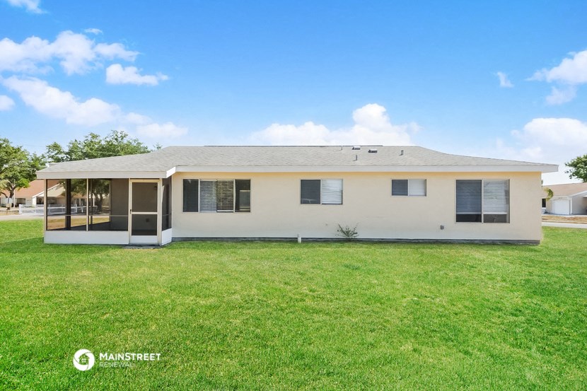 a white house with a lawn and a blue sky