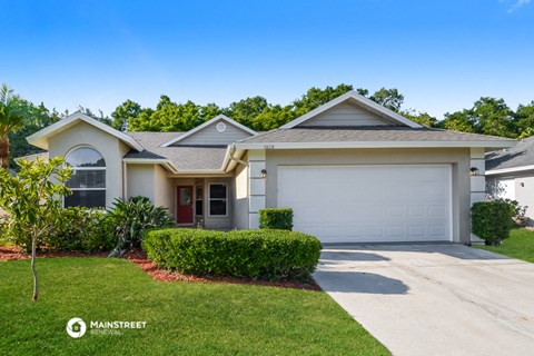 a home with a white garage door and a lawn