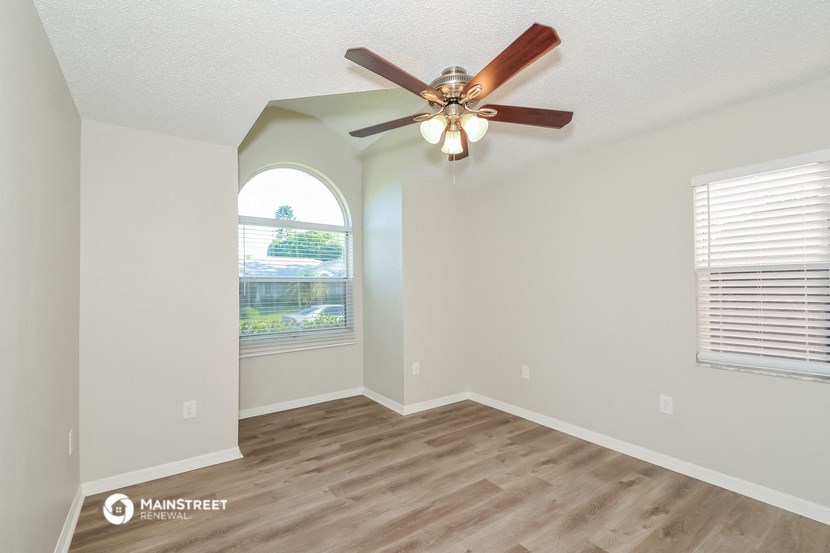 a living room with a ceiling fan and a window