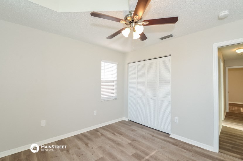 the living room of our two bedroom apartment atrium with ceiling fan and window