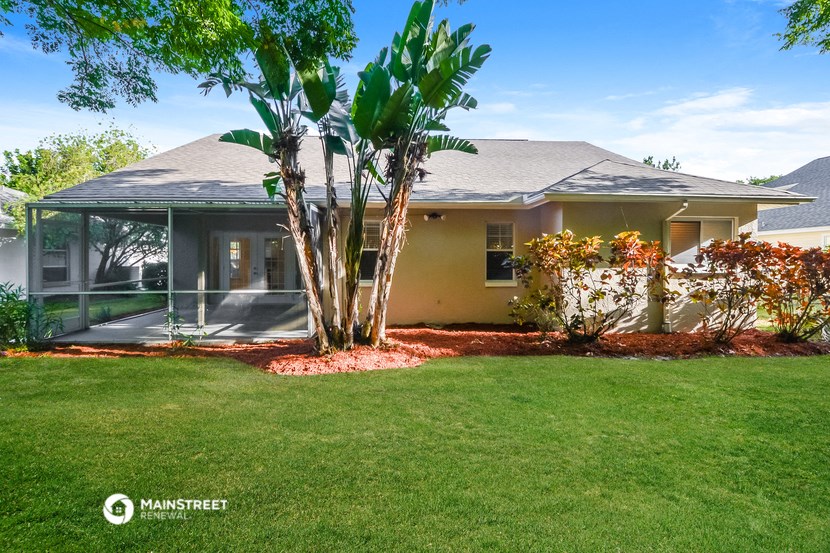 a house with a yard and a palm tree in front of it