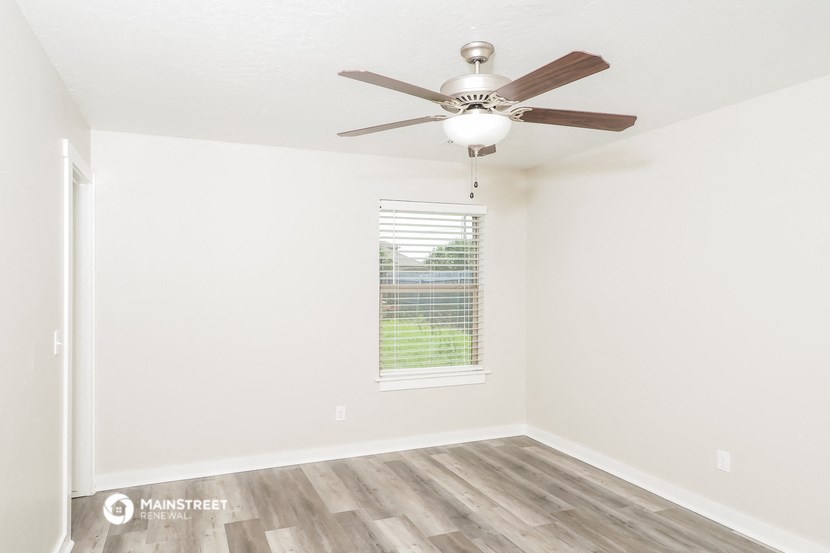 the living room of our studio apartment atrium with a ceiling fan