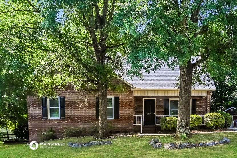 a small brick house with two trees in front of it