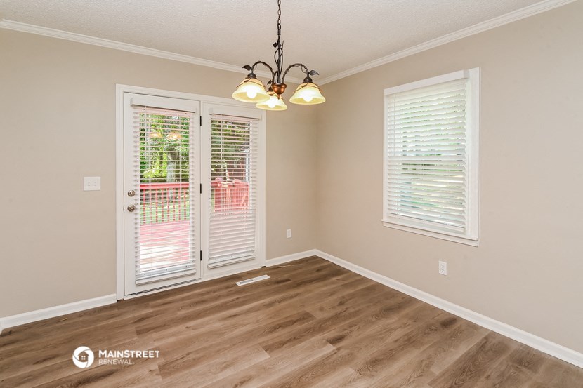 the living room of a home with a wood floor and a chandelier