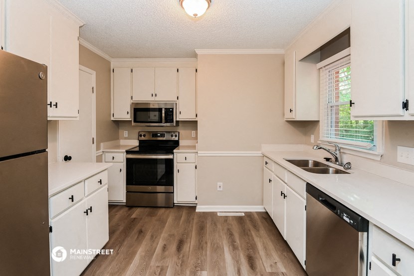 a kitchen with white cabinets and stainless steel appliances