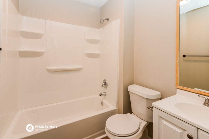 a bathroom with a tub and a toilet and a sink