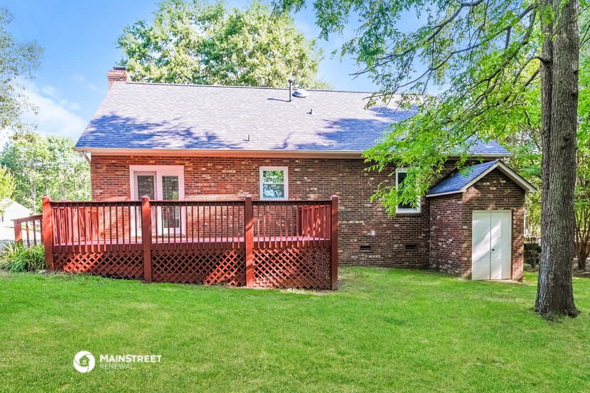 a red brick house with a deck and a garage