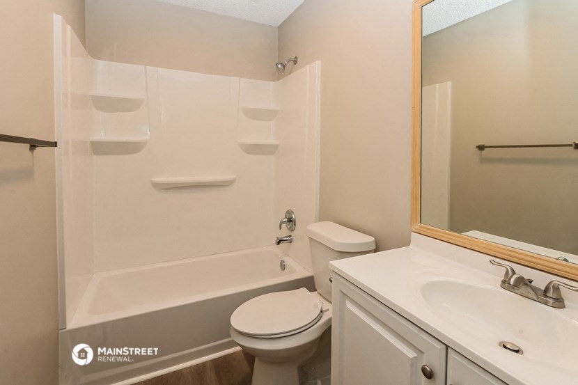 a bathroom with a toilet and a tub and a sink