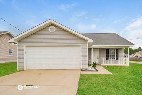 a gray house with a white garage door and a lawn