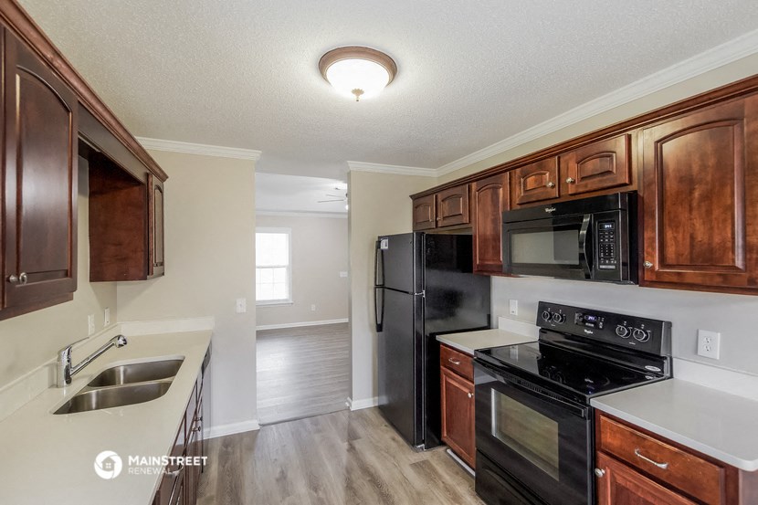 a kitchen with black appliances and wooden cabinets