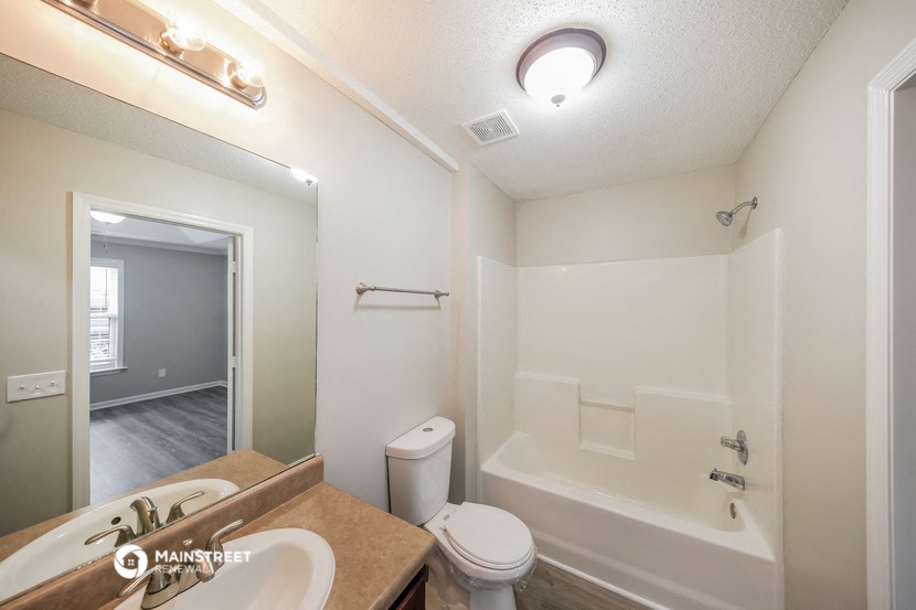 a bathroom with a shower toilet and sink and a mirror