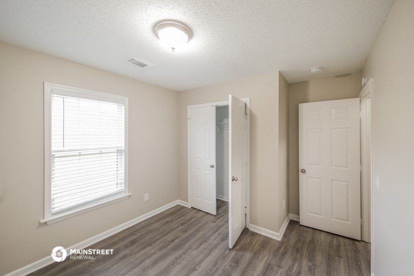 the interior of a renovated bedroom with a closet and a window