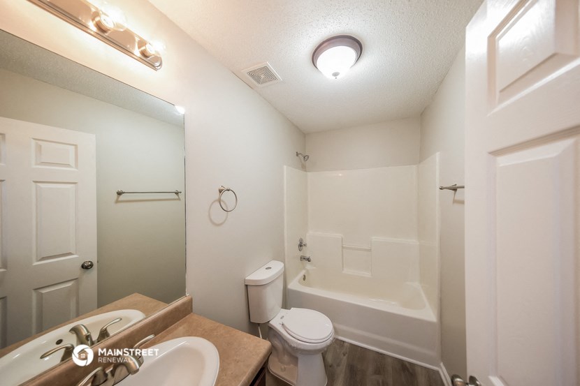 a bathroom with a toilet and a tub and a sink