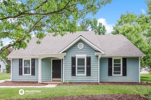 a blue house with a tree in front of it