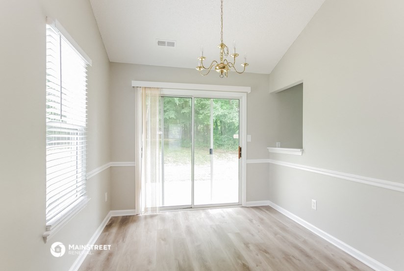 an empty living room with white walls and a sliding glass door
