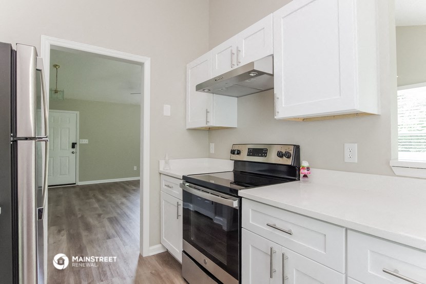 a renovated kitchen with white cabinets and black appliances