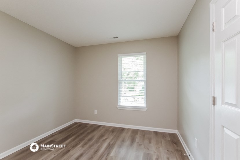 an empty room with wooden floors and a window