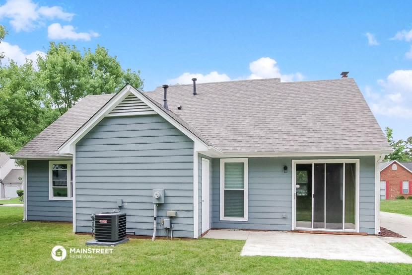 the front of a blue house with a grey roof