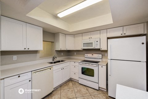 a white kitchen with white appliances and white cabinets