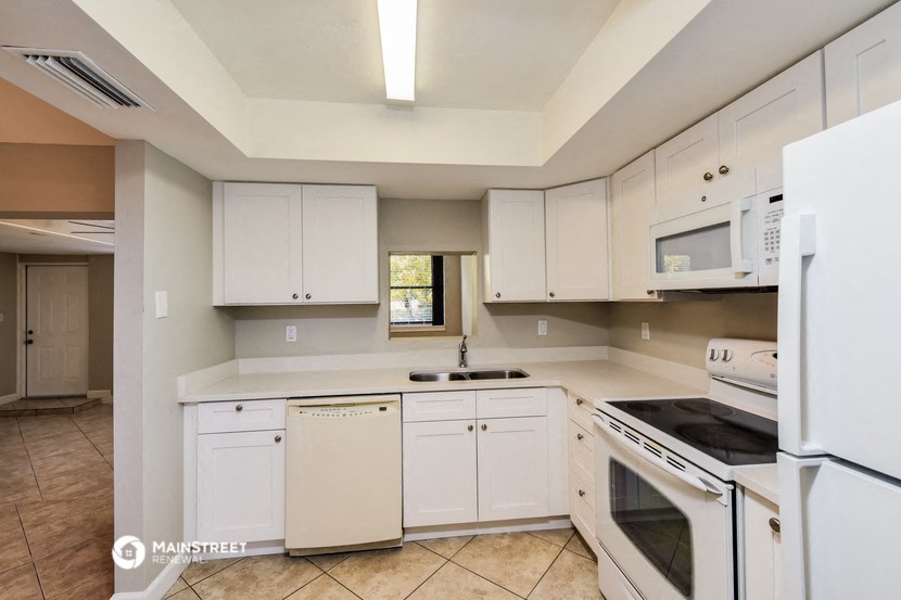 a kitchen with white cabinets and appliances and a sink