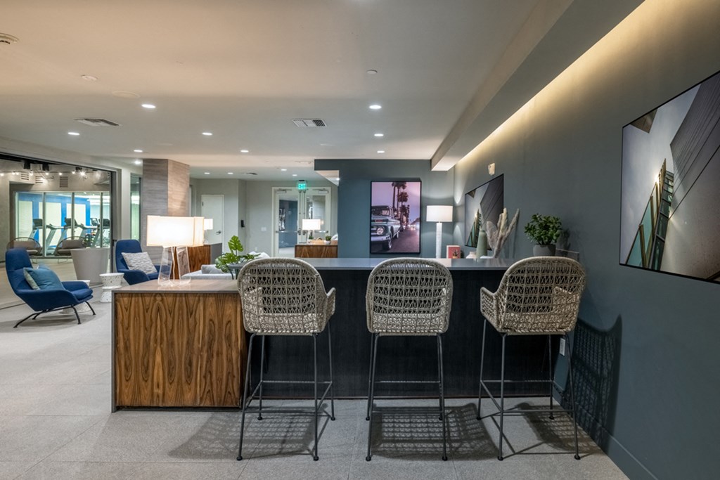 a lobby with chairs and a counter with a bar with high chairs