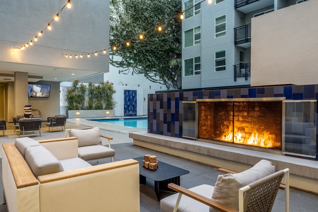 a living room with couches and a fireplace in front of a pool