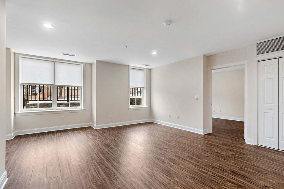 an empty living room with wood flooring and a window