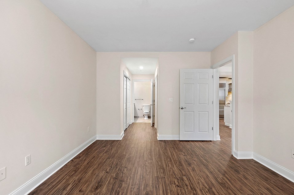 a renovated living room with wood flooring and white walls
