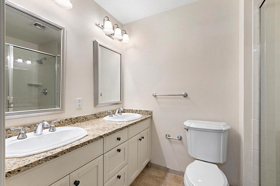 a bathroom with two sinks and a toilet