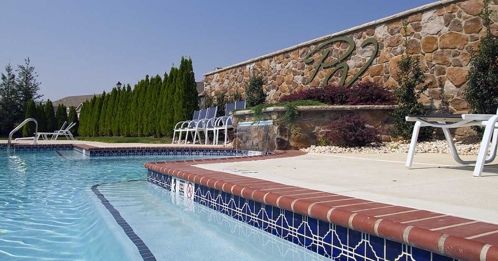 a swimming pool is next to a stone building