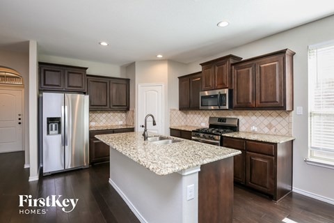 a kitchen with brown cabinets and a granite counter top